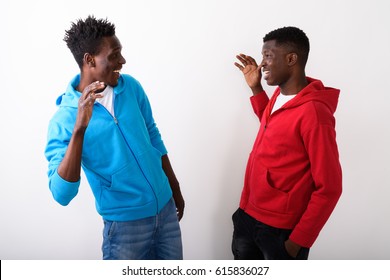 Profile View Of Two Young Happy Black African Friends Giving High Five Together Against White Background