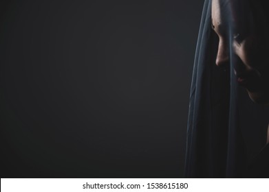 Profile Of A Woman In A Black Veil. Costume Dead Bride For Halloween. Portrait Of An Evil Grinning Witch In Front Of A Coven.