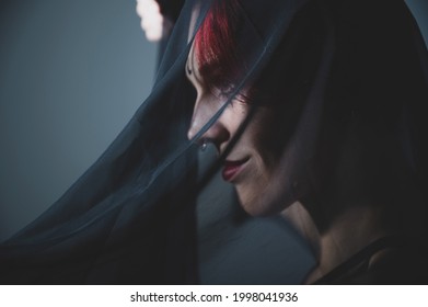 Profile Of A Woman In A Black Veil. Costume Dead Bride For Halloween. Portrait Of An Evil Grinning Witch In Front Of A Coven.