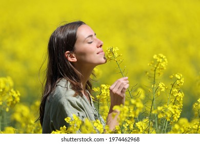 Profile of a woman smelling flowers in a yellow field - Shutterstock ID 1974462968