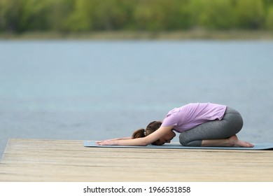 Profile Of A Yogi Doing Yoga Exercise In A Lake Pier
