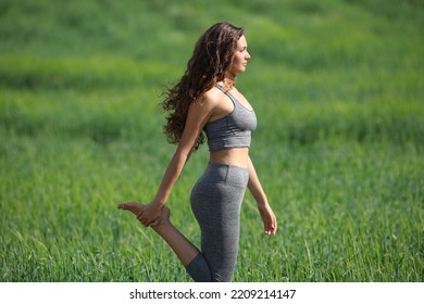Profile Of A Yogi Stretching Leg After Yoga Standing In A Field