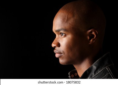 Profile Of A Young Afro-American Man Against A Black Background.