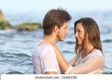 Profile of a young couple in love bathing in the sea in the beach                - Shutterstock ID 216061381