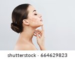 Profile of young female with clean fresh skin, antiaging concept. Girl touching face with closed eyes, lifting arrows showing facial anti-aging treatment on skin