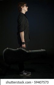 Profile Of Young, Handsome Man With Guitar Case