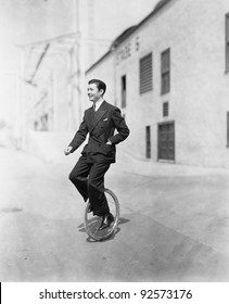 Profile Of A Young Man Riding A Unicycle