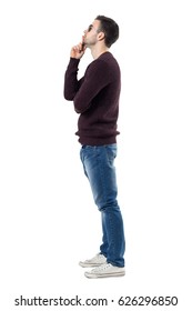 Profile Of Young Man Wearing Maroon Pullover And Sunglasses Thinking And Looking Up. Full Body Length Portrait Isolated Over White Studio Background. 