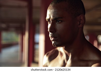 Profile Of Young Serious Athletic Black Man Looking Away At Sunny Day. Close Up Face Of Handsome Bald Guy On Blur Background