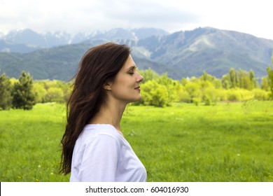 Profile Of Young Woman With Eyes Closed Breathing Fresh Air In The Mountains.