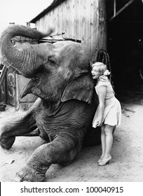 Profile of a young woman hugging an elephant