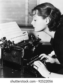 Profile of a young woman typing musical notes with a typewriter