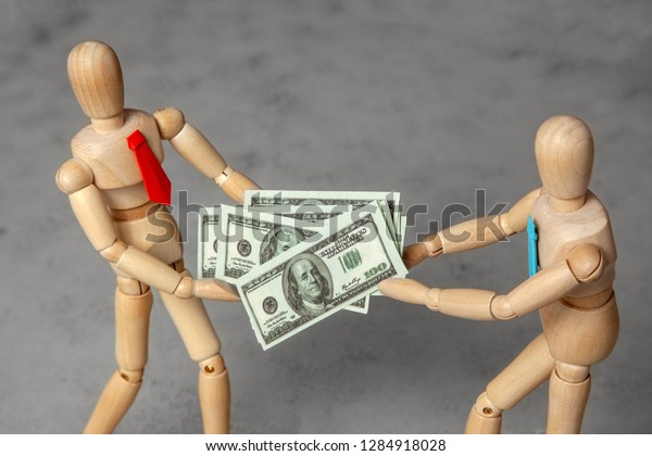 Profit sharing between\
partners. Two businessmen divide cash dollars among themselves.\
Fight for money
