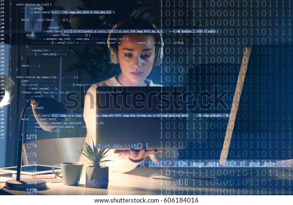 Program development concept. Young woman\
listening to music while working with\
laptop