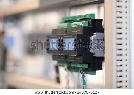 Programmable logic controllers mounted on DIN rail in a rack. Selective focus.