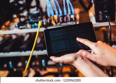 Programmer adjusting cryptocurrency mining rig to optimal operational settings