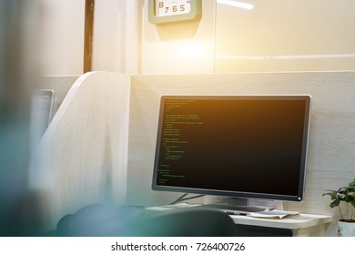 programmer from behind and programming code on computer monitor. focus on monitor