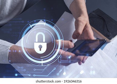 A programmer is browsing the Internet in smart phone to protect a cyber security from hacker attacks and save clients confidential data. Padlock Hologram icons over the typing hands.