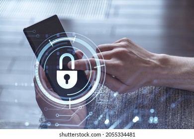 A programmer is browsing the Internet in smart phone to protect a cyber security from hacker attacks and save clients confidential data. Padlock Hologram icons over the typing hands.