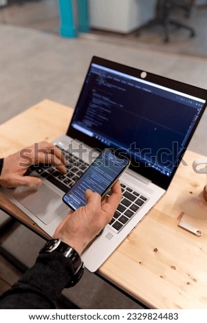 A programmer coding at lap top at coworking space. High quality photo