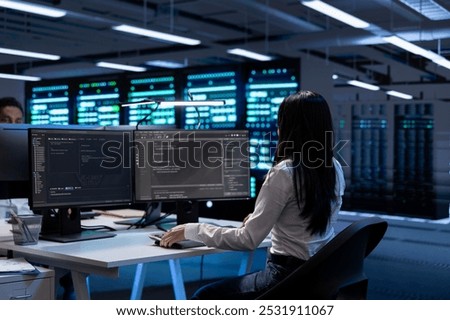 Programmer in data center checking equipment performance on computer after upgrading hardware. IT specialist doing checkup on storage devices and networking equipment in servers hub