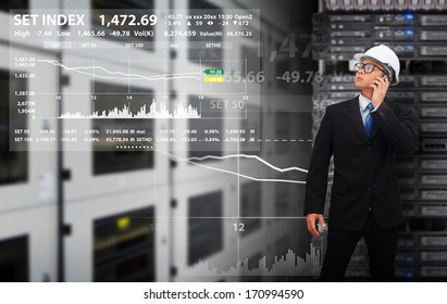 Programmer in data center room looking on graph report