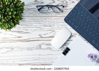 Programmer Desk Flat Lay Design. Glasses, Laptop, Keyboard, Mouse, Papers, Houseplants On The Table.