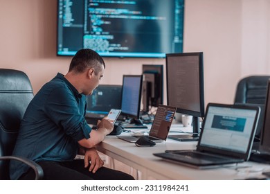 A programmer diligently testing smartphone applications while sitting in their office. - Shutterstock ID 2311984241