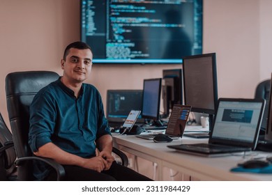A programmer diligently testing smartphone applications while sitting in their office. - Shutterstock ID 2311984429