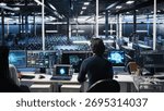 Programmer entering server room office, using AI to review infrastructure diagnostics. IT admin in data center high tech facility analyzes performance data using artificial intelligence tech, camera A