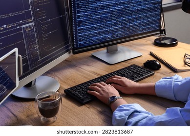 Programmer hands typing on a keyboard with multiple computer screens displaying code software development and IT, this setup software development information technology and data analysis concepts