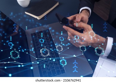 Programmer holding in the hands a smart phone and testing an innovative application to provide a completely new service. Close up shot. Hologram tech graphs. Concept of Dev team. Formal wear. - Shutterstock ID 2106762941