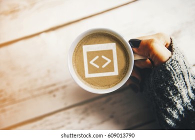 Programmer morning concept: coding symbol in a cup of coffee