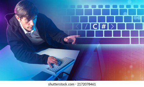 Programmer points to C# logo. C Sharp mark on keyboard buttons. Generating C# code. Software development with C Sharp. Man programmer in front of computer. Modern programming languages.