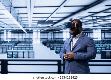 Programmer in server hub using VR headset to implement and maintain security measures, protecting systems from unauthorized access. Data center employee does hardware maintenance using virtual reality