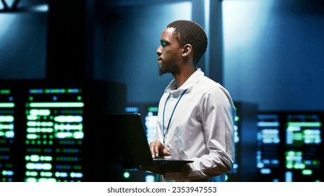 IT programmer setting up high tech facility advanced firewalls, intrusion detection systems and security updates. Cybersecurity supervisor preventing hacking, malware, and denial of service attacks - Powered by Shutterstock