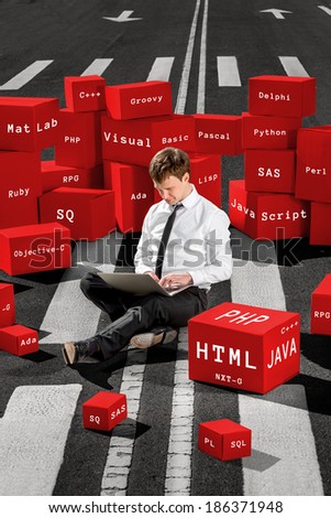 Programmer sitting and working with laptop on the asphalt road surrounded with red boxes with different programming languages