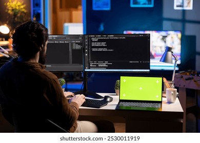 Programmer using isolated screen laptop to secure company servers from virus attacks. IT remote employee writing code, building firewalls protecting data using chroma key notebook