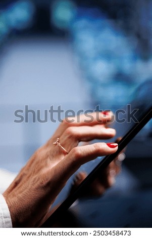 IT programmer using tablet to make sure valuable data remains shielded from security drawbacks, safeguarding high tech workplace servers against unauthorized access and vulnerabilities, close up