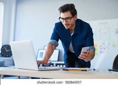 Programmer, web developer, designer working at office comparing mobile and desktop website versions