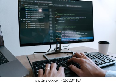 Programmer working On Computer In IT Office Typing Data Coding in software and checking code on computer screen