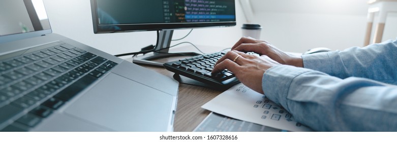 Programmer working On Computer In IT Office Typing Data Coding in software and checking code on computer screen