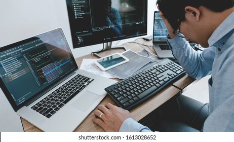 Programmer working On Computer In IT Office Typing Data Coding in software and checking code on computer screen