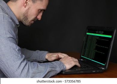 Programmer working on the  laptop, writing programming code.
