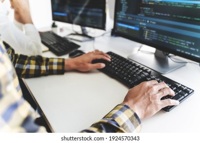 Programmierer schreiben Programmcode mit zwei Monitoren und arbeiten an neuer Software oder Hacker-Programmierung Entwicklung von Software-Anwendungen im Büro.