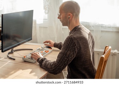 Programmer, young man in brown cable knit sweater working at computer, coding process, modern worker solving problems, specialist digital tasks, home office environment promoting productivity and calm
