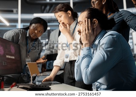 Programmers in data center panicking after viewing malware security breach alert. Disturbed cybersecurity IT experts trying to trace intrusion origin and apply emergency patches