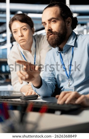 Programmers in data center workplace using computer, verifying firewall configurations. Teamworking colleagues doing brainstorming, performing equipment vulnerability scans in server hub using PC