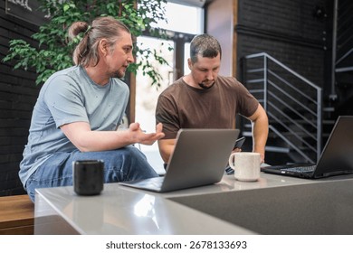 Programmers discussing over laptop working at startup. Office, business and friends together in teamwork with notebook, laptop and coffee workplace