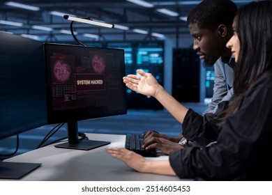 Programmers doing teamwork in server hub trying to protect hardware from hacker stealing information. Colleagues in data center workspace trying to fix security breach alert caused by virus